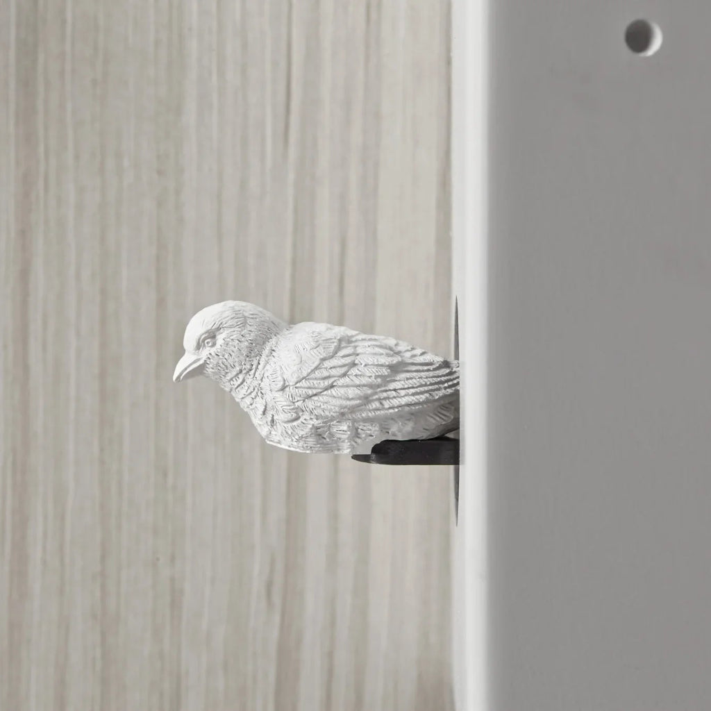 White ceramic dove sculpture on a wooden surface
