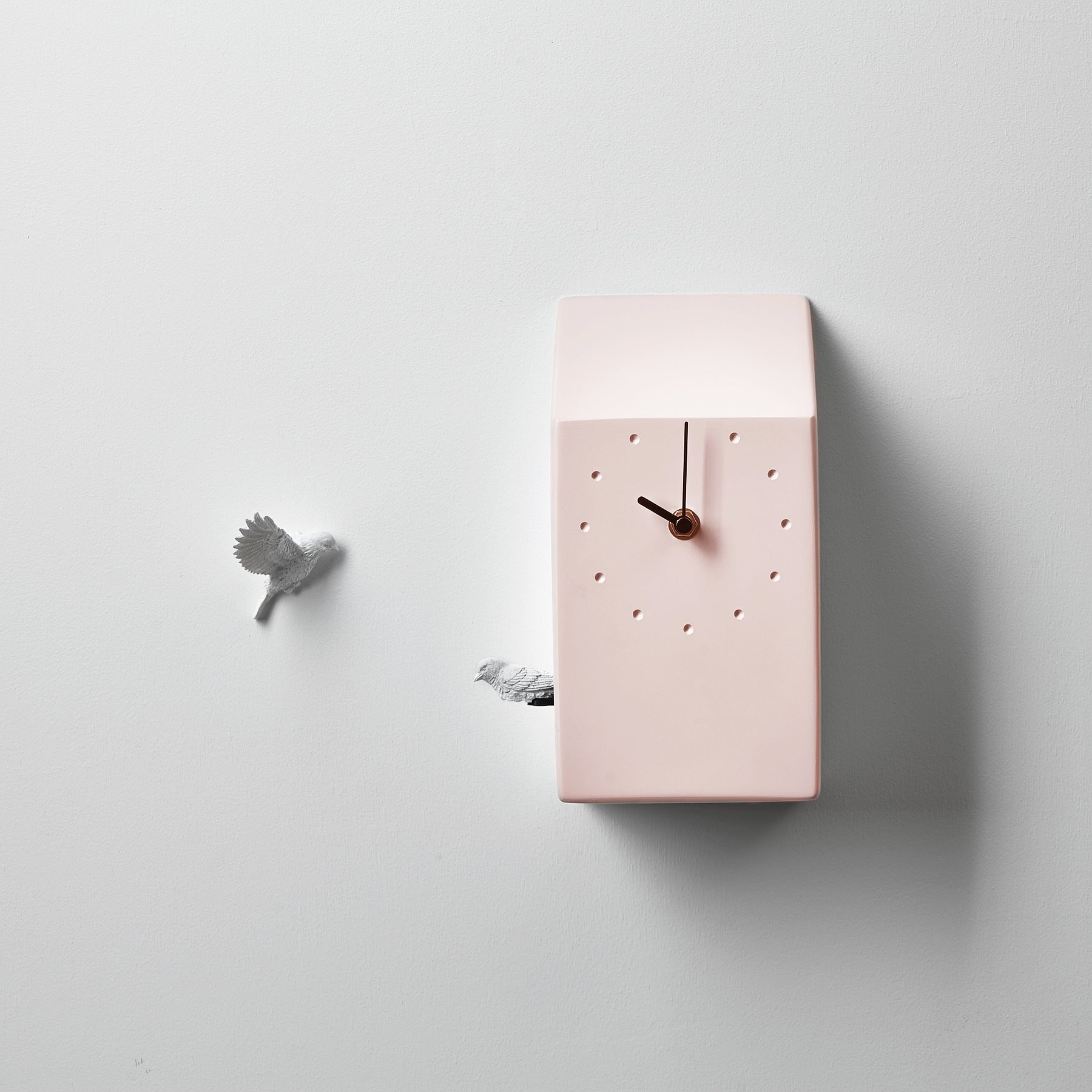 A pink Haoshi cuckoo clock adorned with a bird. available at Spacio retail stores in Mumbaii & Kolkata and online.
