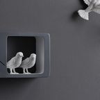 Closer look of Haoshi Sparrow Clock in Dark Gray color on a dark grey wall with small grey boxes available at Spacio india for modern and luxury interiors from our Timepieces and clocks collection.