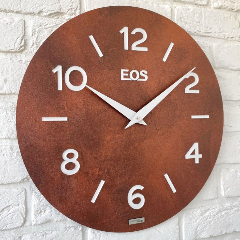 Rust-colored wall clock with 'EOS' branding on a white brick wall background