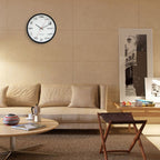 Living room with beige sofa, round coffee table, and wall clock displaying mathematical equations.
