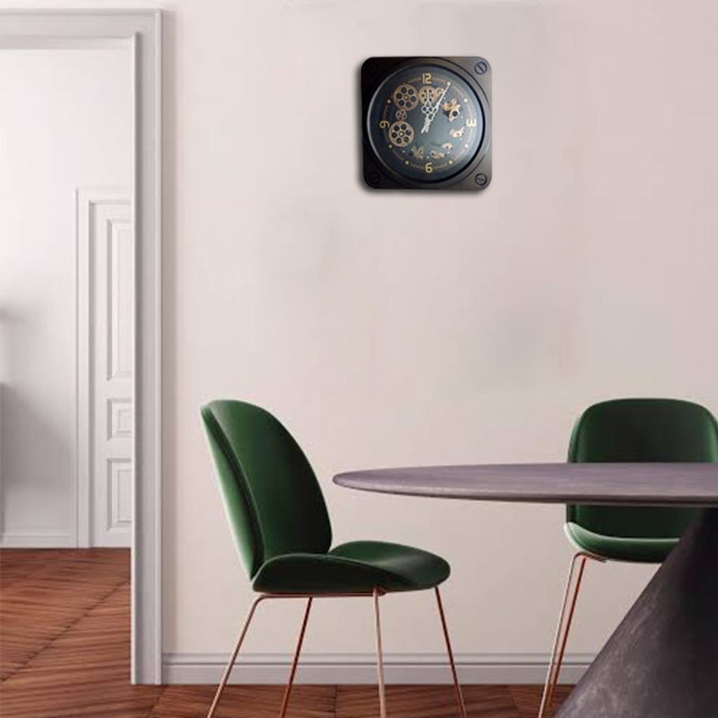 Wall clock with gear design on a white wall above a dining table and chairs.