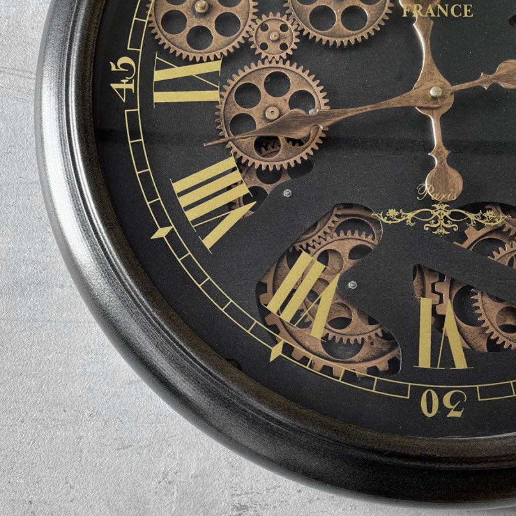 Close-up of a mechanical watch with intricate gears and gold accents on a gray background