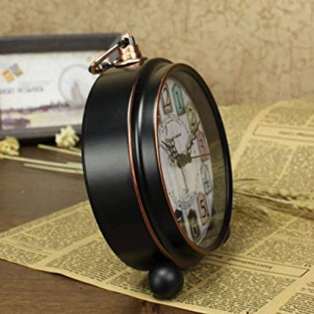 Vintage-style alarm clock on a textured surface with a blurred background