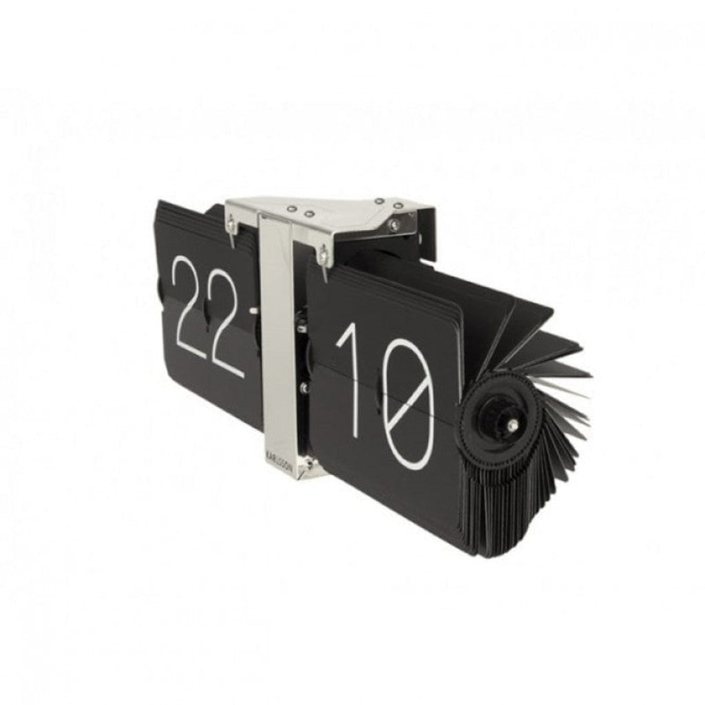 Black flip clock with white numbers on a white background