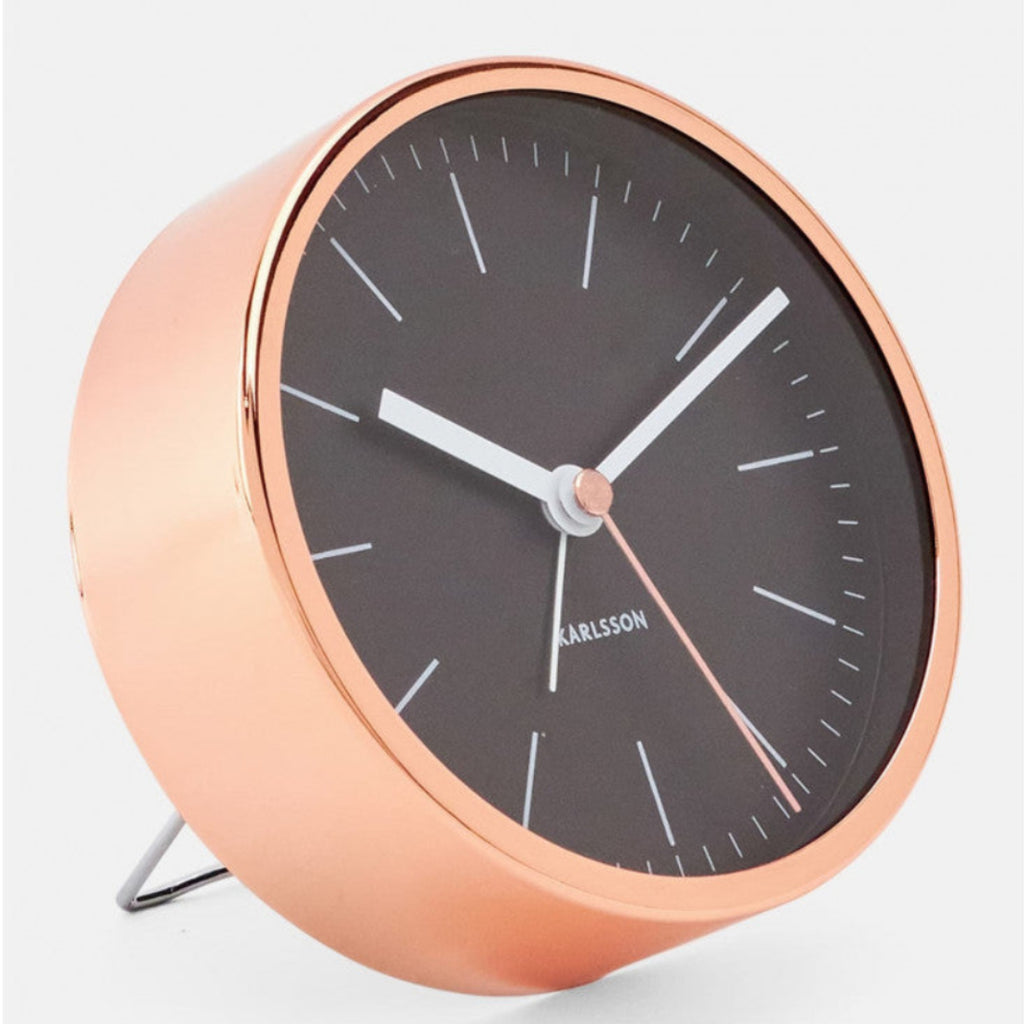 Rose gold clock with black face on a white background