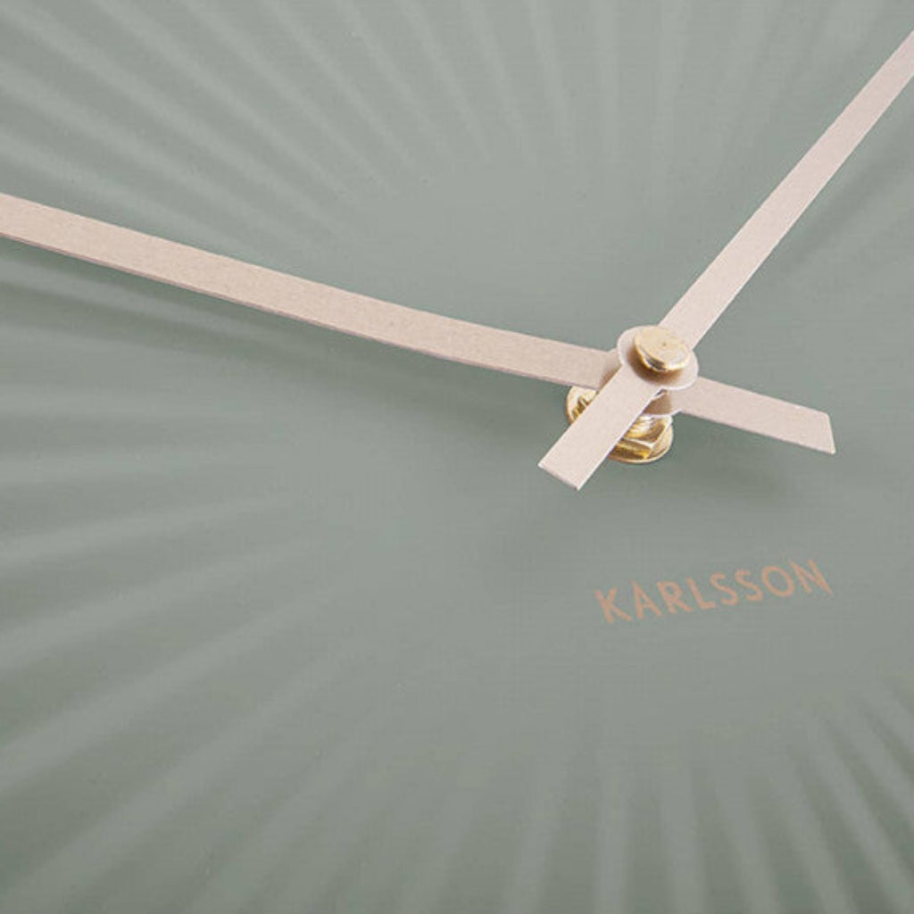 Green wall clock with gold hands and 'KARLSSON' branding