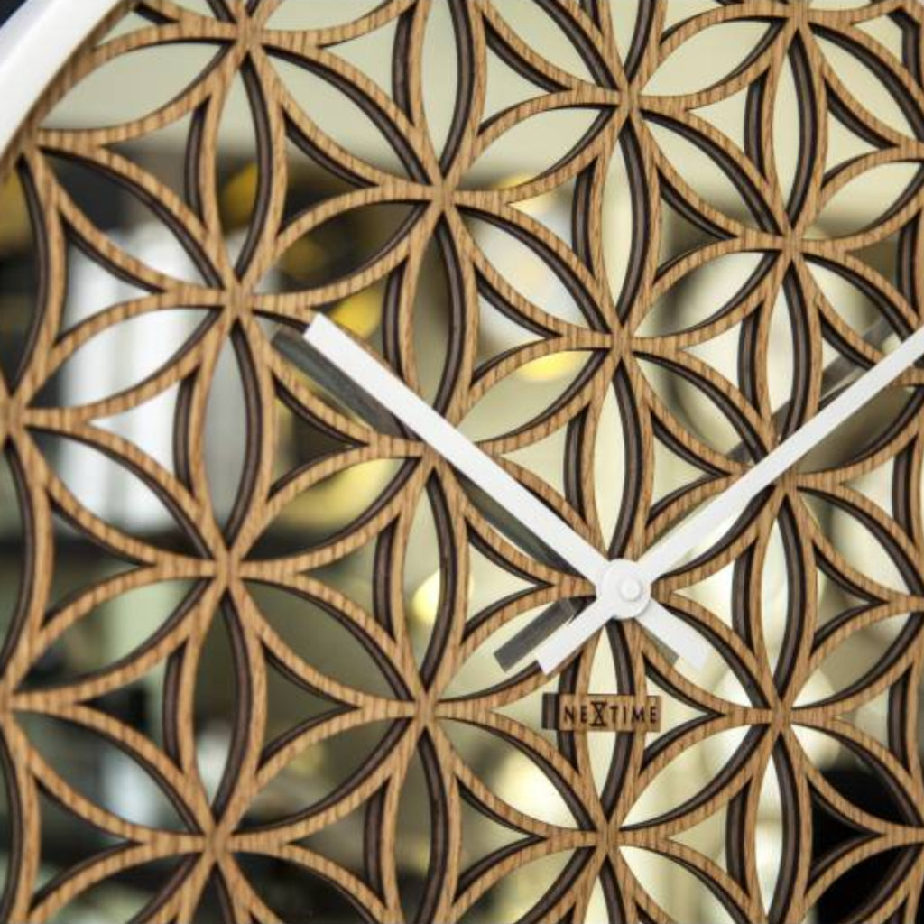 Wall clock with geometric wooden design and white hands on a black background