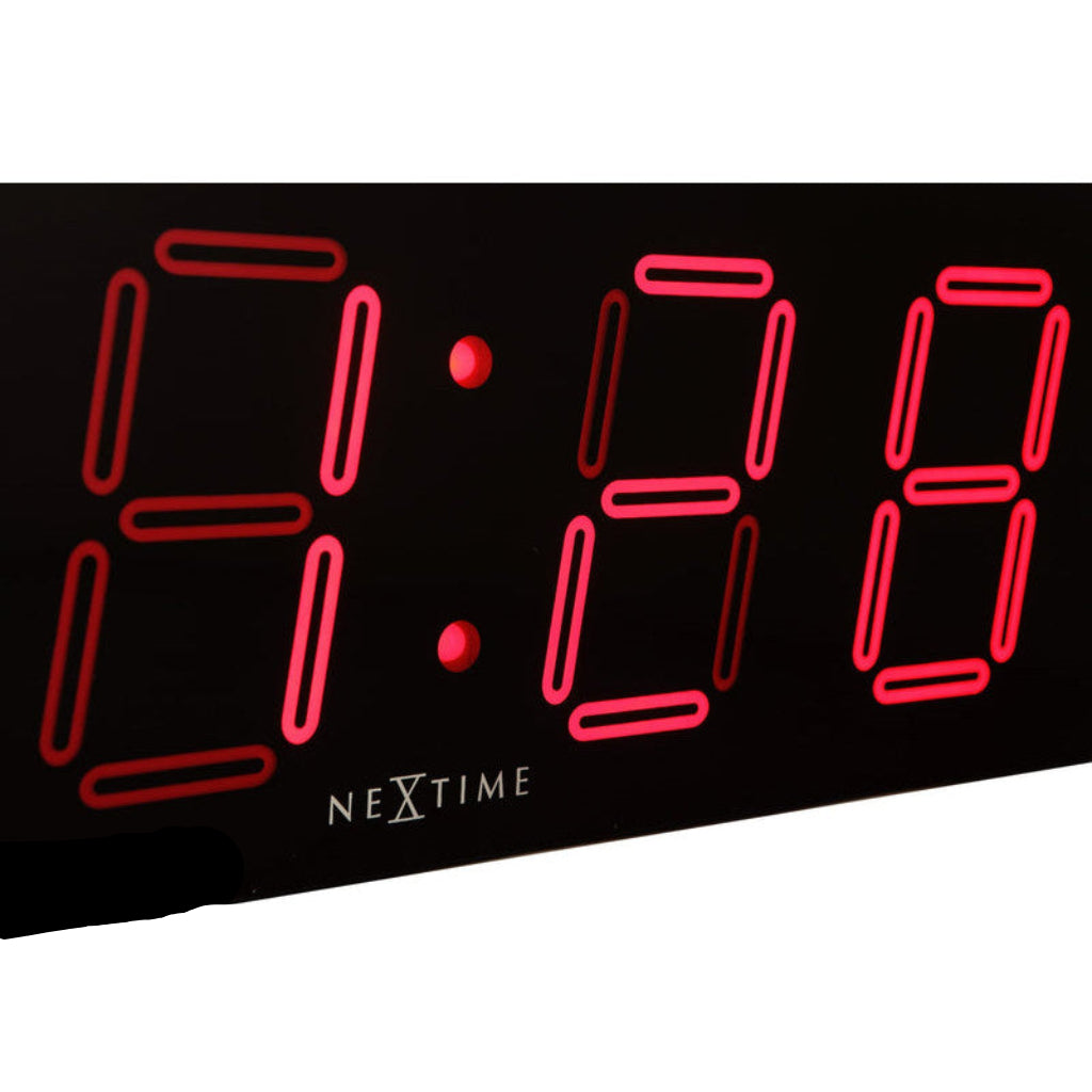 Digital clock with red LED digits displaying '9:00' on a black background, featuring the brand 'Nextime'.