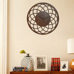 Decorative wall clock on a wall with books and a lamp in the background