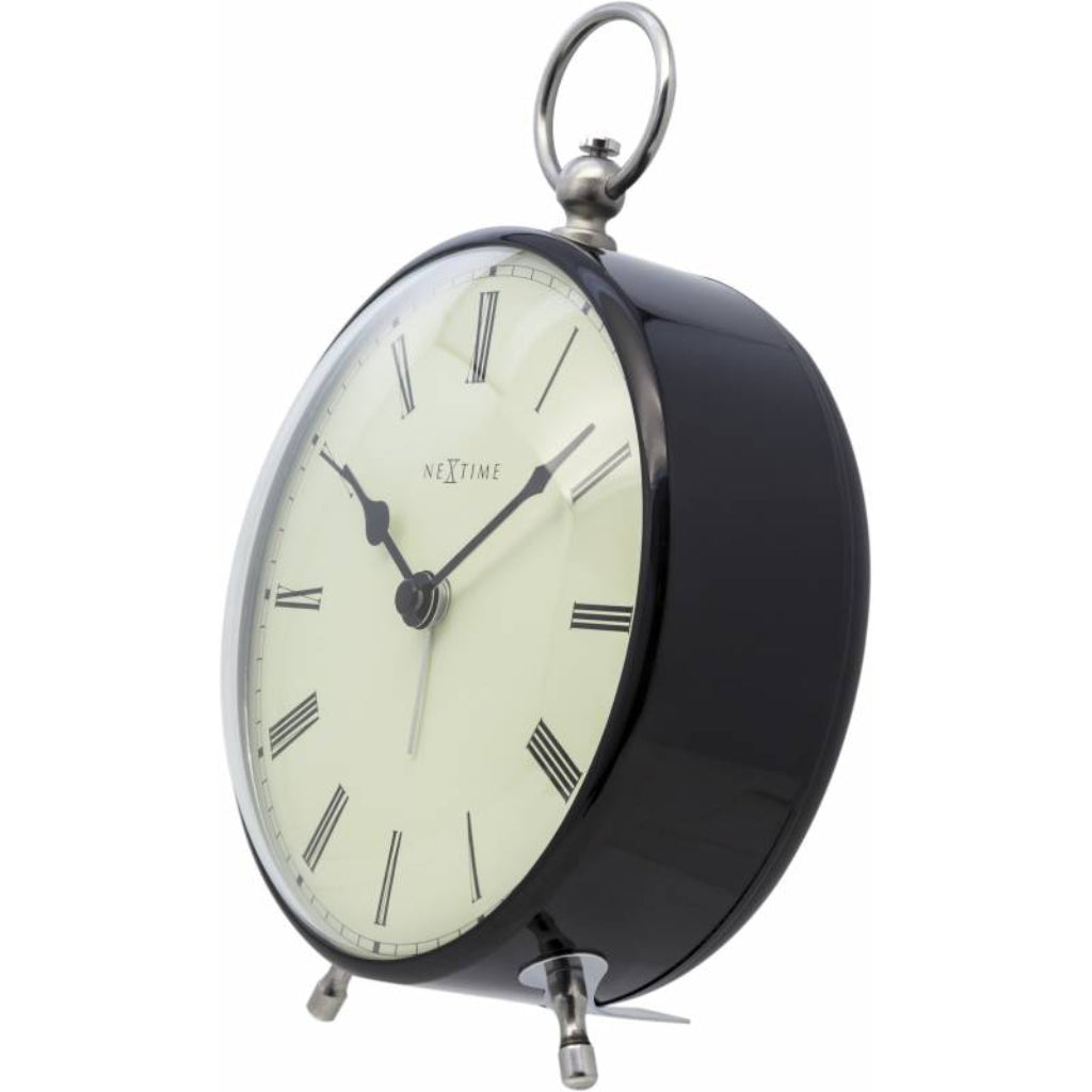 Black table clock with white face and Roman numerals on a white background