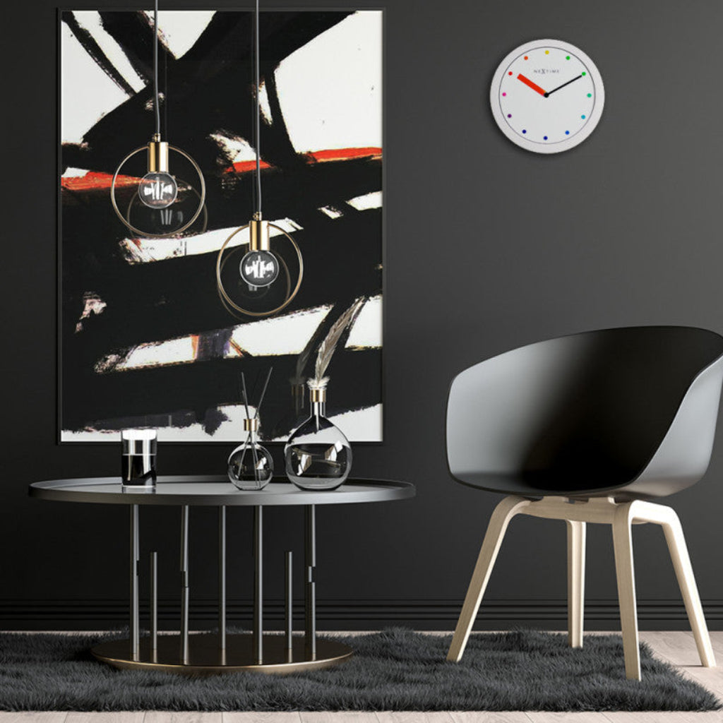 Modern interior with abstract painting, round table, and chair against a black wall.