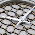 Close-up of a clock with decorative metalwork on the face