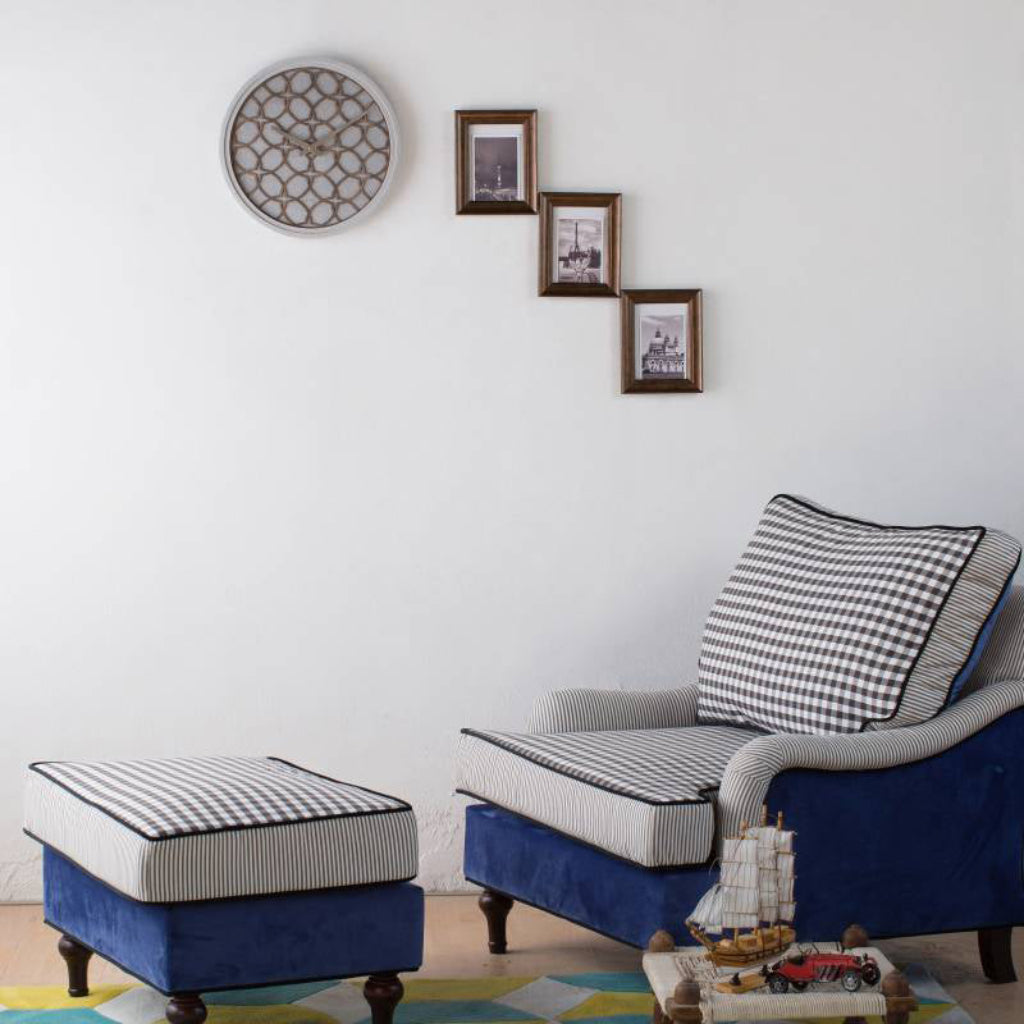 Navy blue and white checkered armchair with matching ottoman in a room with framed pictures on the wall.