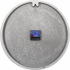 Round metallic object with a small electronic component on a white background