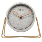 Table clock with gray textured face and gold metal stand on a white background