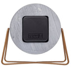 Round concrete-like object with a black square label and bronze frame on a white background