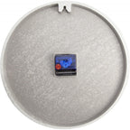 Round metallic object with a small electronic component on a white background