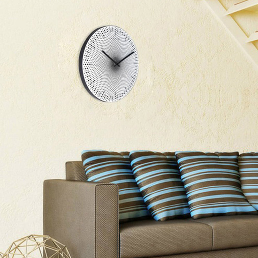 Wall clock on a wall above a sofa with striped cushions