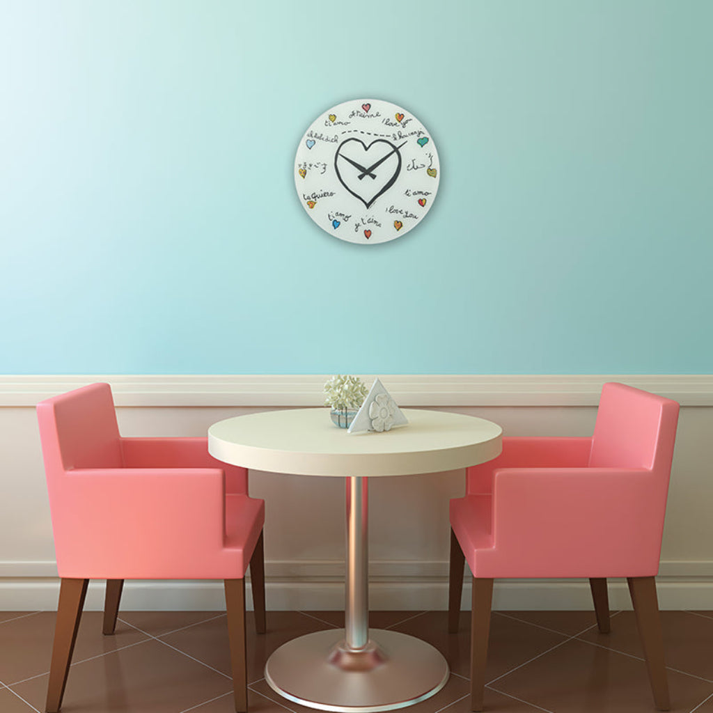 Round table with two pink chairs against a light blue wall with a decorative clock.