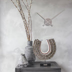 Decorative vases and wall clock on a gray surface with a light gray background