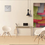 Modern office space with a desk, chairs, and colorful abstract art on the wall.