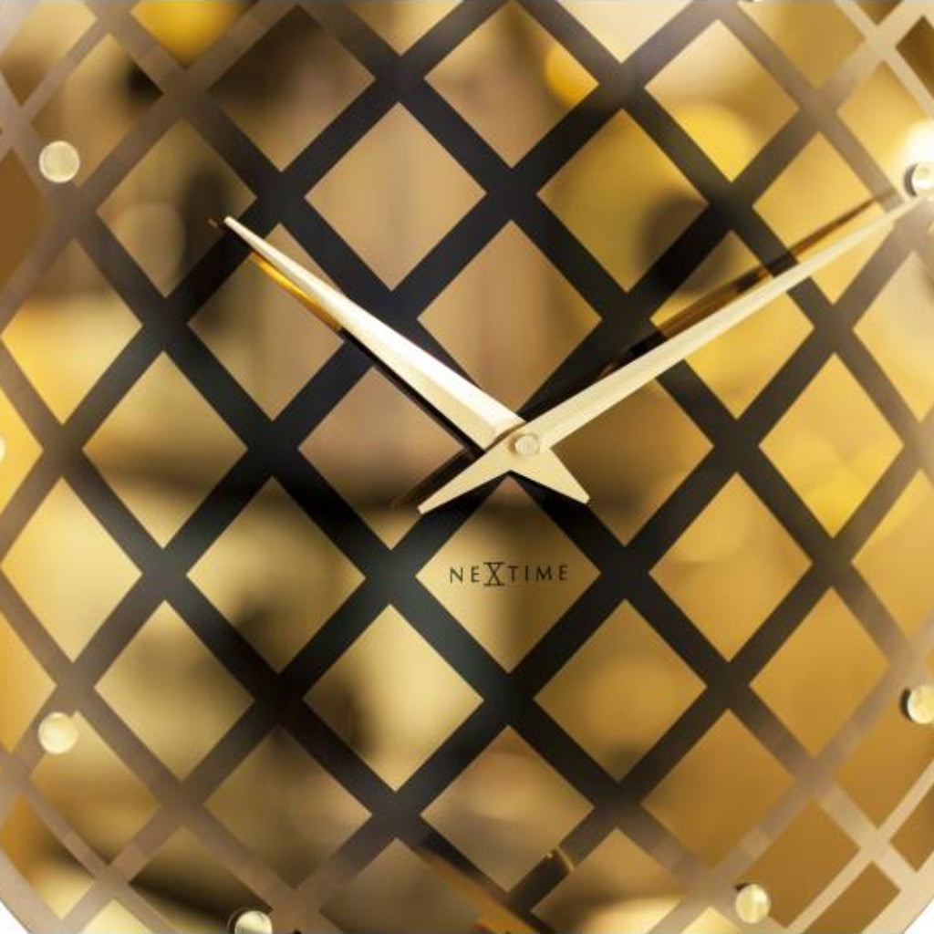 Gold wall clock with geometric design on a white background