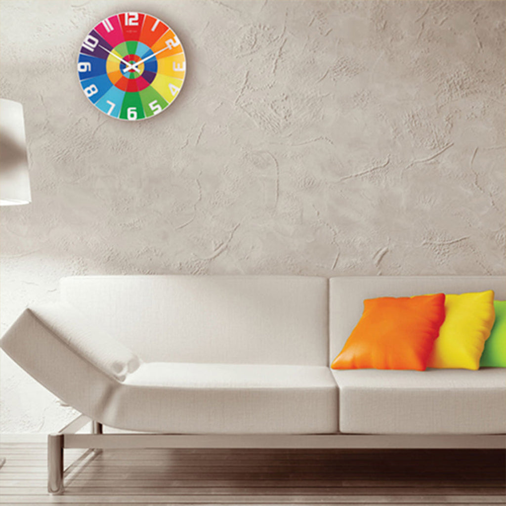 Colorful wall clock on a textured wall above a white sofa with colorful cushions.