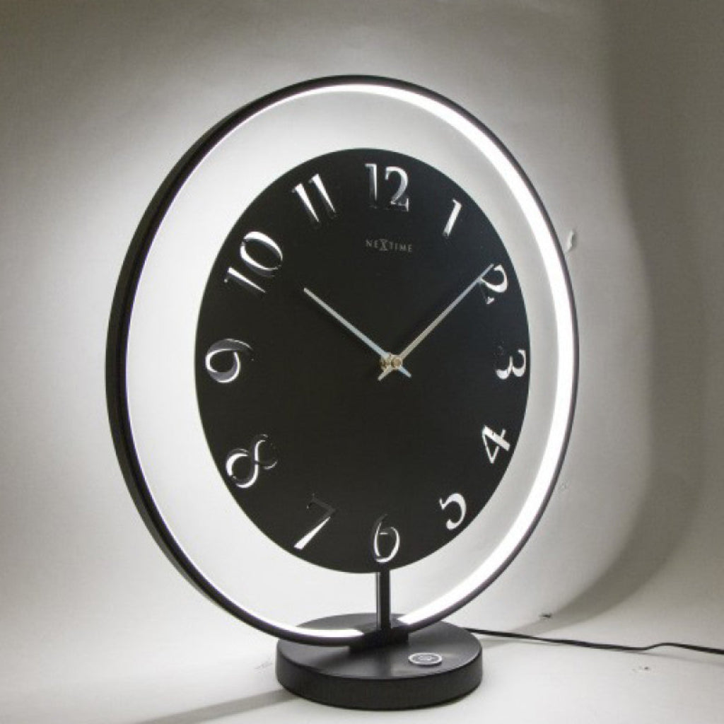 Black table clock with illuminated rim on a white background