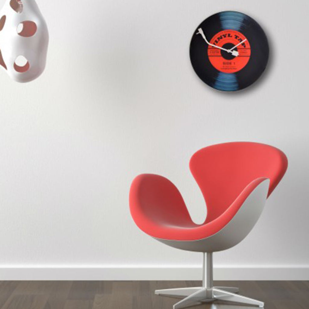 Red chair and vinyl record clock on a white wall