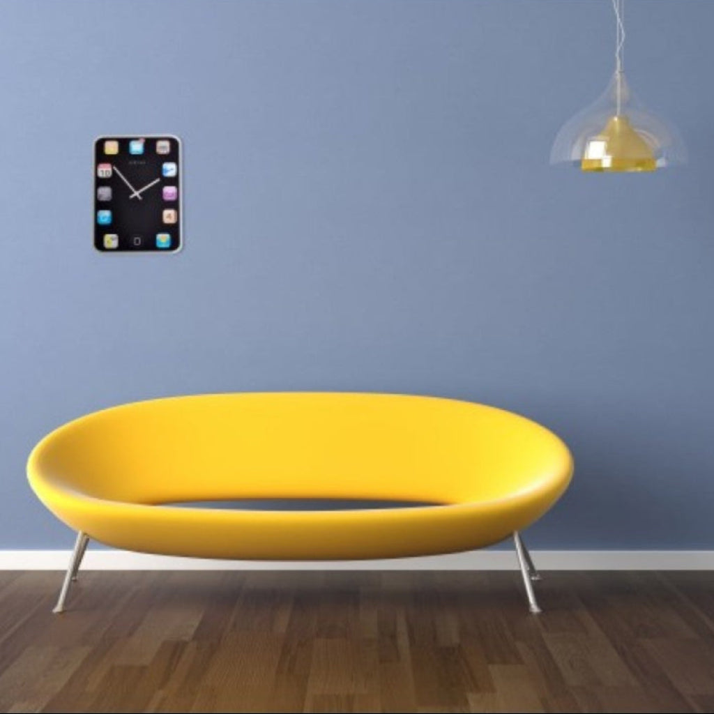 Yellow sofa against a blue wall with a clock and light fixture.