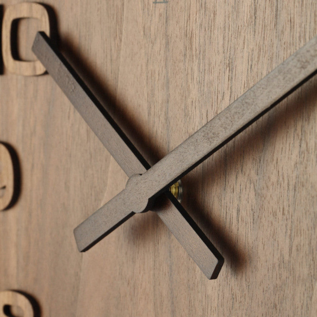 Wooden wall clock with a minimalist design on a wooden background