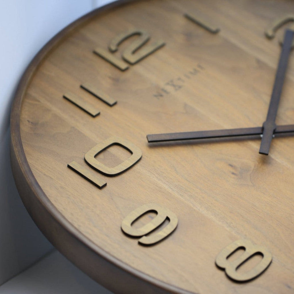 Wooden clock with black hands on a light background