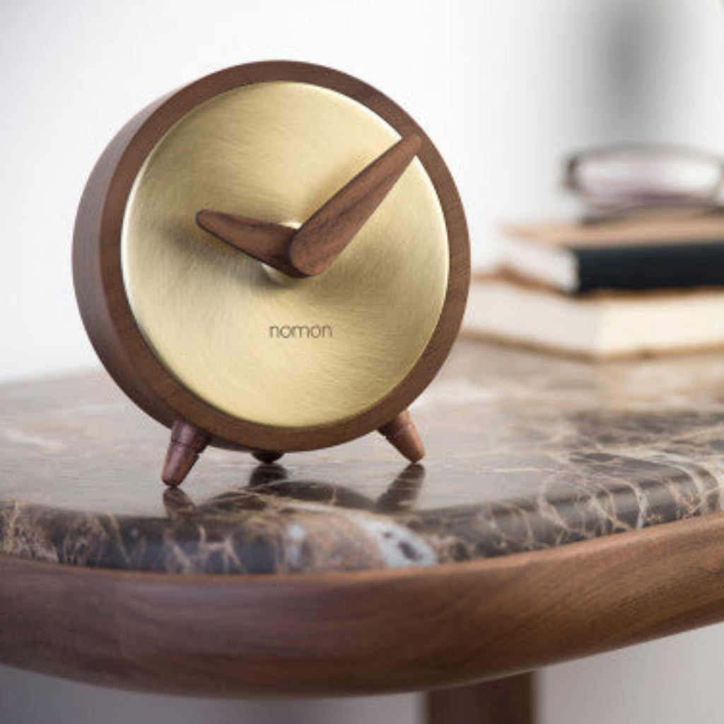 Wooden clock with brass face on a marble surface