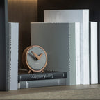 Small round clock on a stack of books with a dark background