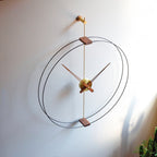 Modern wall clock with gold and wood accents on a white wall