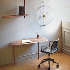 Modern office setup with a desk, chair, and wall clock.