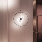 Modern wall clock on a light pink wall