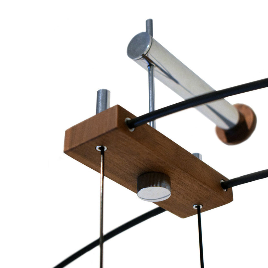 Close-up of a ceiling-mounted light fixture with wooden base and metal components on a white background