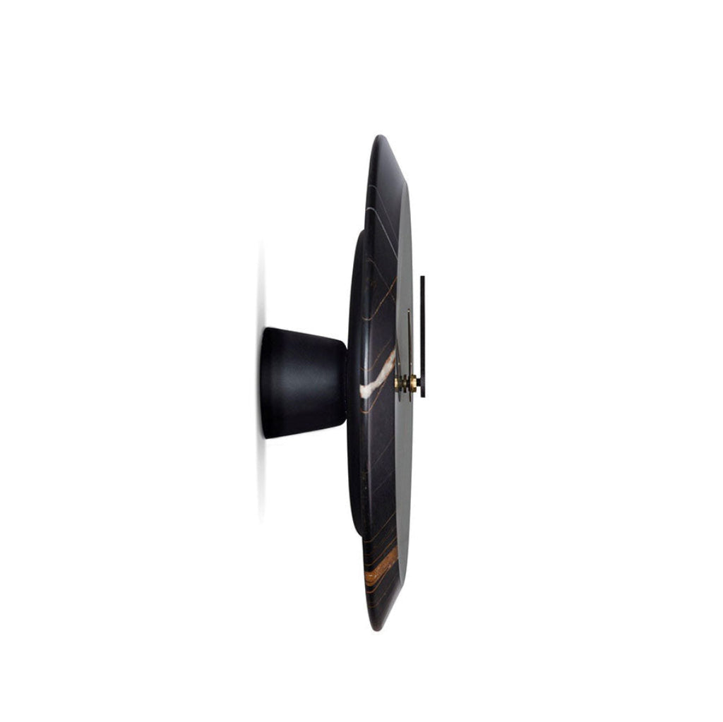 Modern wall clock with black and gold design on a white background