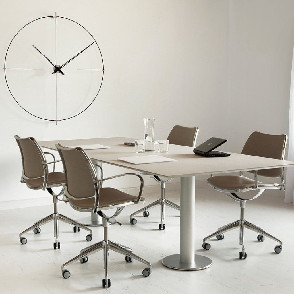 Modern office setting with a conference table and chairs, featuring a large wall clock.