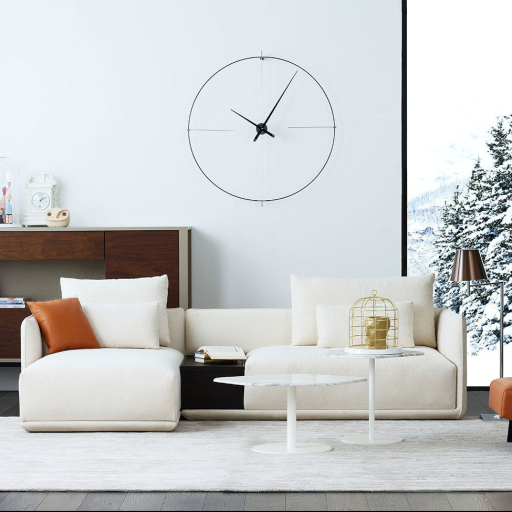 Modern living room with a white sofa, decorative pillows, and a wall clock.