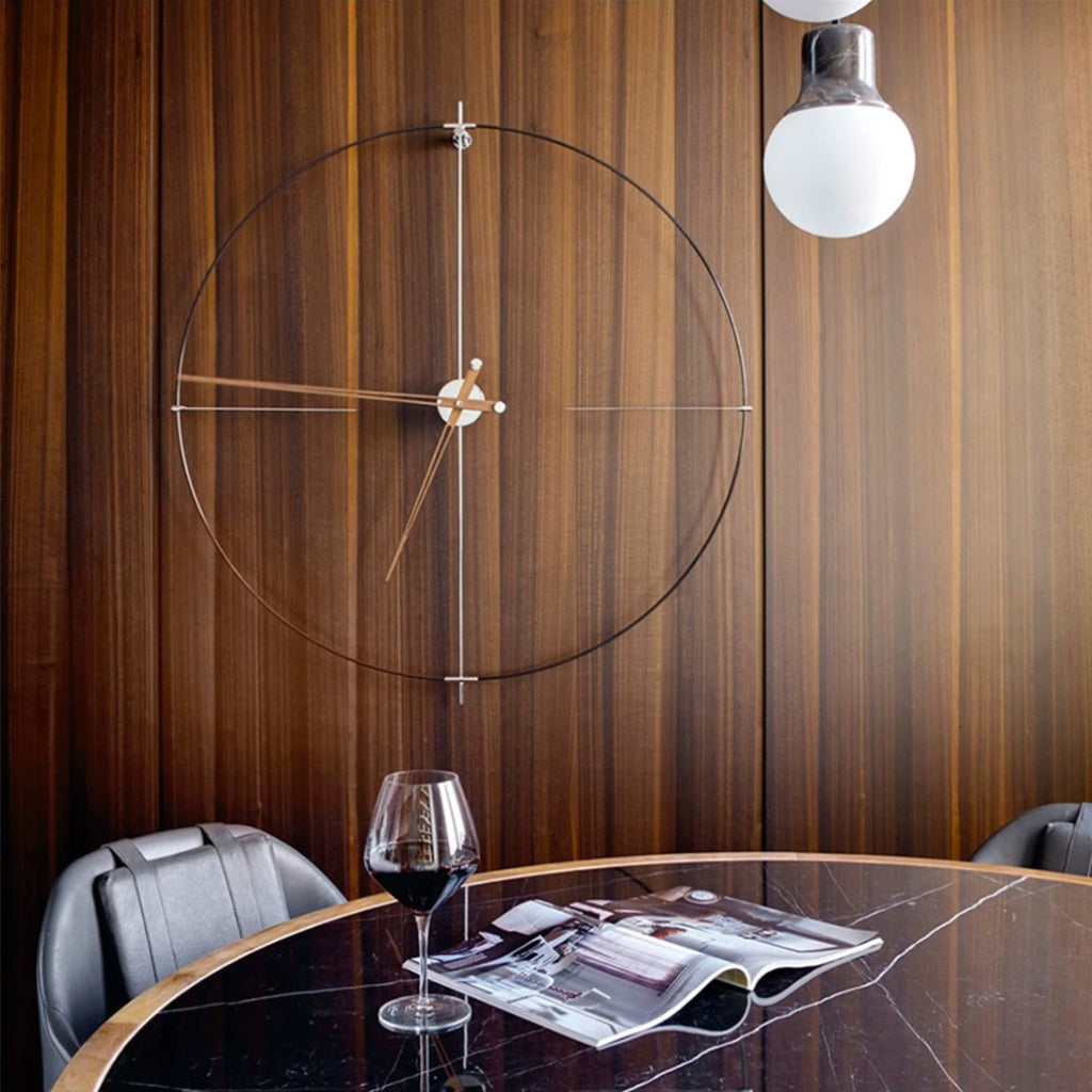 Modern interior with a round table, glass of red wine, and magazine against a wooden wall with a circular design.