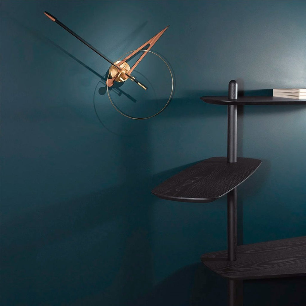 Modern wall clock with gold accents on a dark teal wall