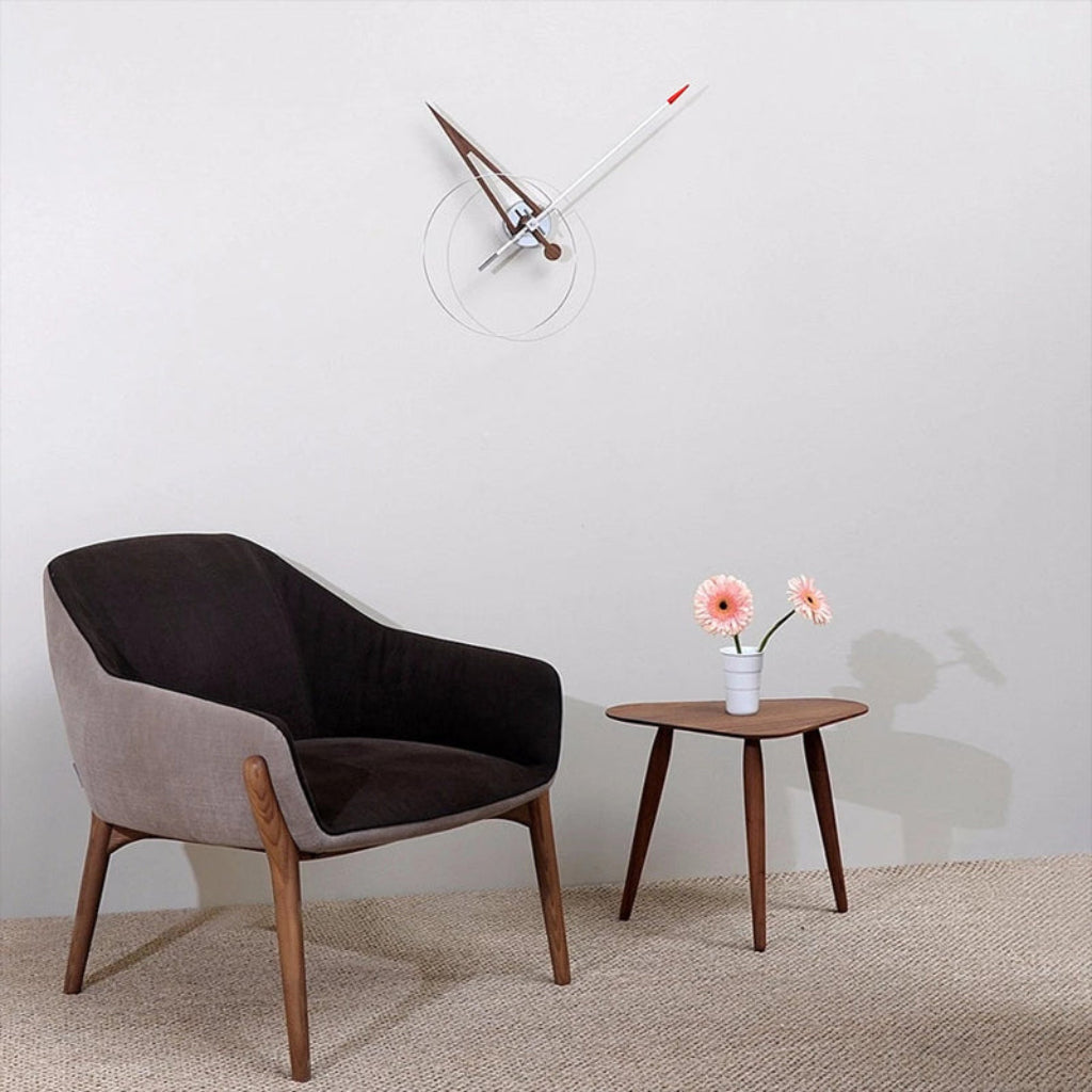 Modern chair and side table with a minimalistic wall clock in a room.