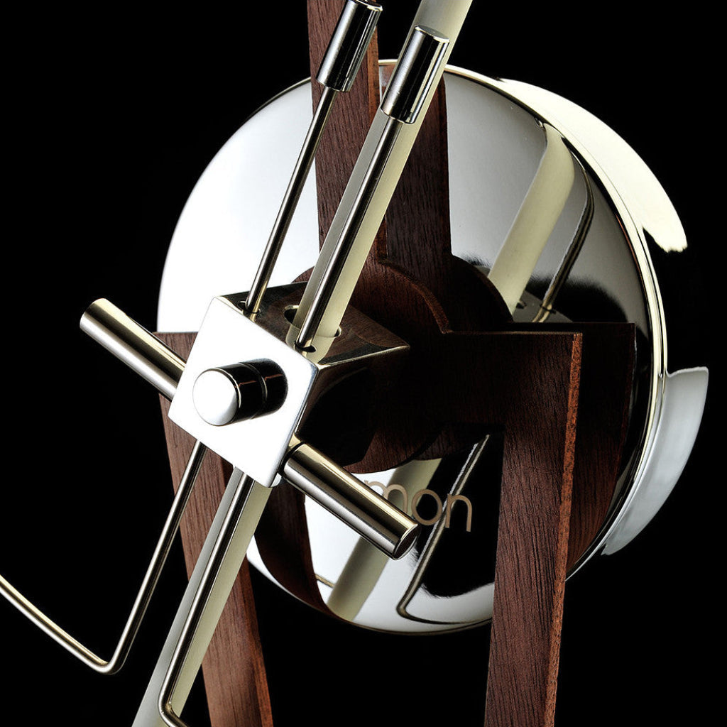 Close-up of a decorative wall clock with wooden and metal design on a black background