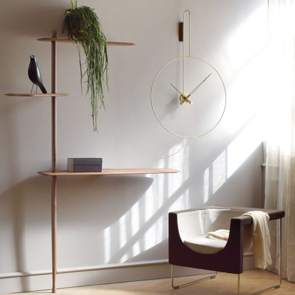 Modern interior with a wall clock, plant, and chair in a well-lit room.