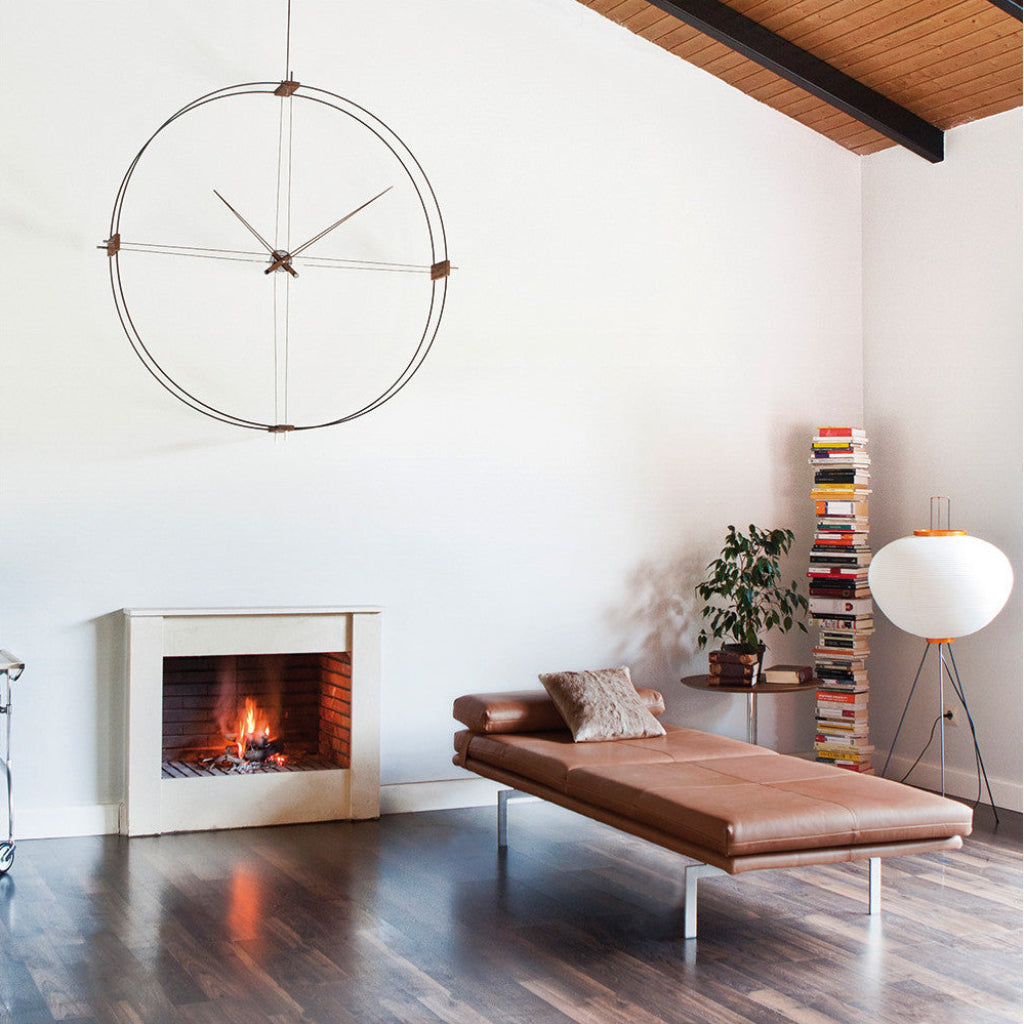 Modern living room with a fireplace, brown leather sofa, and decorative items.