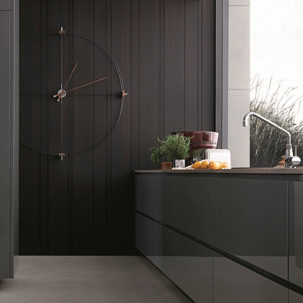 Modern kitchen with dark cabinets and a clock on the wall.