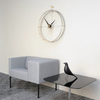 Modern living room with a gray sofa, black glass table, and decorative wall clock.